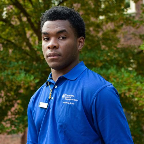DUS Leadership Council member Daniel, standing in front of the Grange building