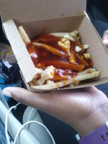 A serving of Poutine. French fries topped wiht cheese curds and gravy.